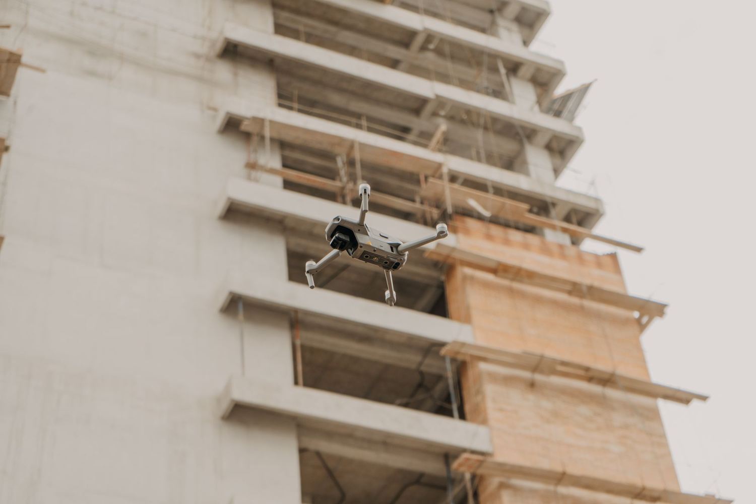 Drone en vol devant un bâtiment en construction