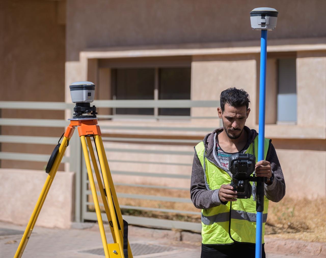 Technicien Palmeraie Topo avec récepteur GNSS RTK sur canne